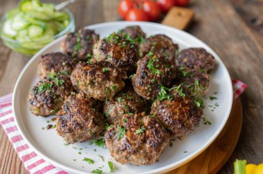 Lezzetli ve ev yapımı köfteler ahşap masa arkasında bir tabakta.