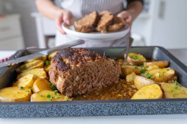 Taze ve ev yapımı köfte ve patates mutfakta önlüklü bir kadın tarafından hazırlandı.