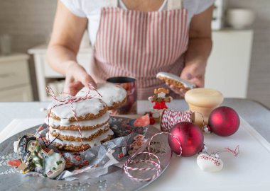 Homemade christmas gingerbread cookies fresh decorated by a woman in the kitchen. Traditional german elisen gingerbread clipart