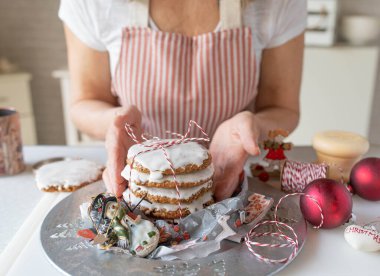 Homemade christmas gingerbread cookies fresh decorated by a woman in the kitchen. Traditional german elisen gingerbread clipart