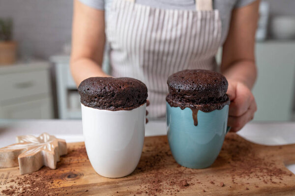 Свежеиспеченные пирожки с микроволновой печью, подаваемые женщиной в фартуке на кухне
