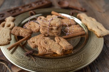 Alman spekülasyon kurabiyeleri taze ve ev yapımı ahşap masada altın bir Noel tabağında..