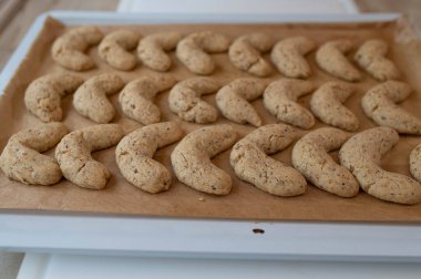 Homemade fresh baked and hot vanilla crescents on a baking tray clipart