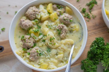 Delicious homemade cooked potato cauliflower soup with meatballs on a plate clipart