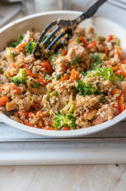 Kızartma tavasında hindi göğsü ve sebzeli sağlıklı kahverengi pirinç tavası.