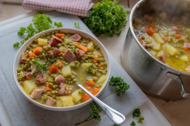 Homemade hearty pea soup with pork meat and vegetables on a plate. clipart