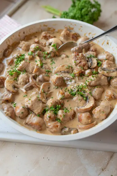 Mantar krem soslu sucuk. Kızartma tavasında kırsal Alman yemeği