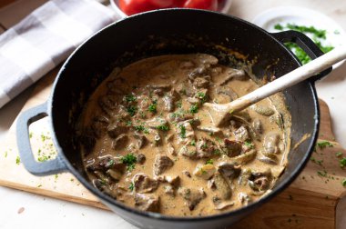 Lezzetli kremalı mantarlı goulash stroganoff usulü biftek, tencerede turşu sosu.