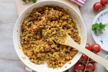 Pirinç ve sebzeli nohut körisi. Taze ve ev yapımı. Dekore edilmiş arka planda kızartma tavasında pişirilmiş.