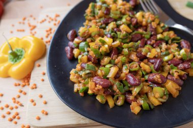 Lezzetli vejetaryen salatası, kırmızı mercimek, fasulye ve tabakta sarı dolma biber.