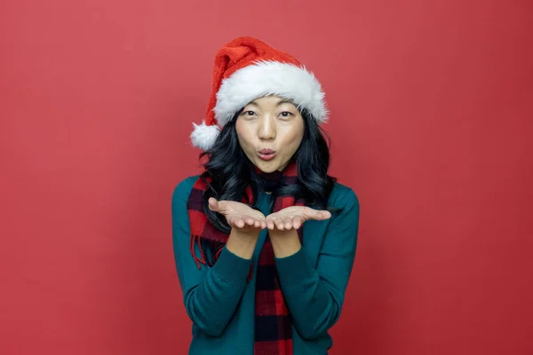 Mooie Glimlachende Aziatische Vrouw Warme Kerst Trui Santa Hoed Blaast — Stockfoto