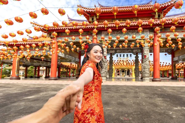 在农历新年期间 身穿红色旗袍的亚洲女人牵着情人的手参观中国佛寺 以弘扬传统文化观念 — 图库照片
