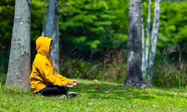 Man Yellow Hoodie Relaxingly Practicing Meditation Forest Attain Happiness Inner — Stock Photo, Image