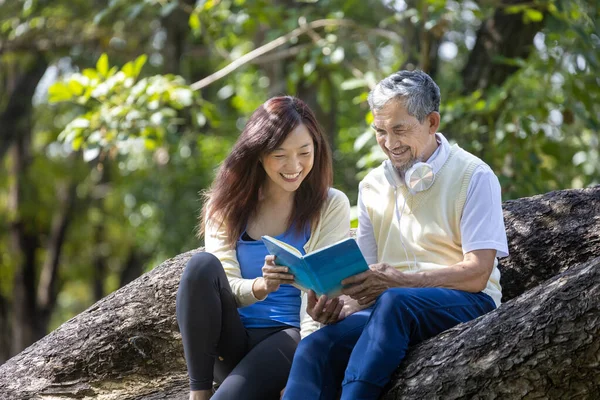 Asian Senior Father Daughter Sitting Reading Book Together Branch Mature — Stock Photo, Image