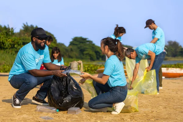 Team of young and diversity volunteer worker group enjoy charitable social work outdoor in cleaning up garbage and waste separation project at river beach