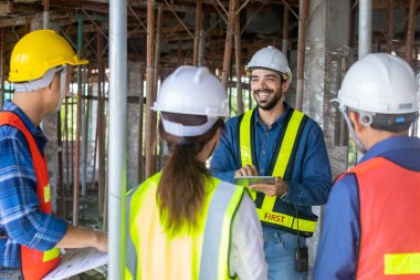 Mühendis, mimar ve ustabaşı ekibi inşaat sahasında gayrımenkul geliştirme projesi endüstrisi ve özelleştirme kalite kontrolü için toplantı ve danışmanlık yapıyor.