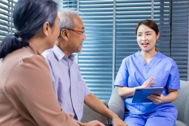 Yaşlı Asyalı çiftlerin yıllık sağlık kontrolü programı için doktorla randevuları var. Hemşire de sağlıklı yaşlanma ve uzun yaşam için kan testi sonuçlarını açıklıyor. 