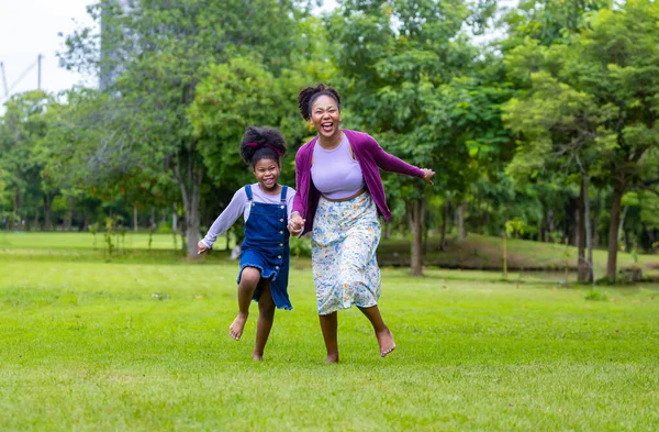 Afroamerykańska Matka Biegnie Boso Trawniku Swoją Młodą Córką Podczas Letniego — Zdjęcie stockowe