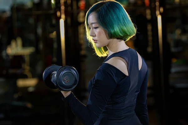 亚洲女人开始练举重时 在健身房里练习哑铃式的手臂和核心肌肉举重 有着黑暗的运动和锻炼背景 — 图库照片