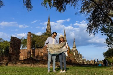 Seyahat, tatil, tatil, balayı ve turizm konsepti için haritalar kullanarak Wat Phra Si Santhe, Ayutthaya Tayland 'a bir çift turist gelir.