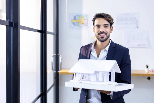 Young Caucasian Architect Holding House Model Working Office Floor Plan — Stock Photo, Image
