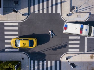 Ciddi şekilde yaralanan yaya, trafik yolu ve ulaşım için taksiyle kan ve kurtarma ambulansıyla kavşağın ortasında yatıyor.