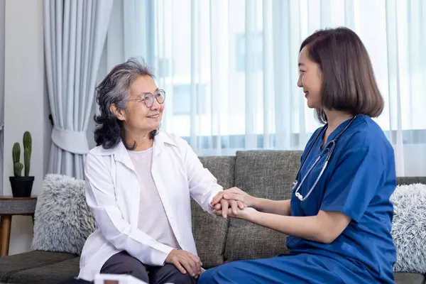 Senior woman got medical service visit from caregiver nurse at home while showing gratitude on appointment for health care and pension welfare insurance