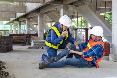 Meslektaşı iş güvenliği ve acil durum için yardım ederken Asyalı fabrika işçileri imalat sahasında çalışırken kaza geçirdi