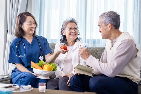 Senior couple get medical advice visit from caregiver nutritionist at home while having suggestion on fresh vegetable meal for healthy eating on probiotic and better digestion system