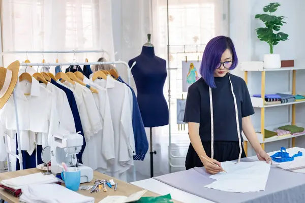 ドレスメーカーは ファッションデザインと衣料品ビジネス業界のための芸術的なワークショップスタジオで働いている間 新しいカスタムメイドドドレスのためのムスリンの調整を行っています — ストック写真