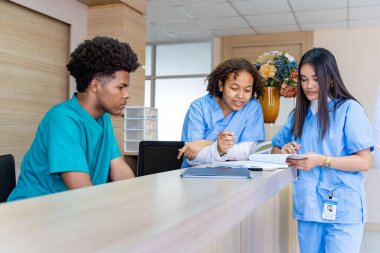 Çeşitlilik doktoru ve hemşire, deneyimli bir hekim uzmanıyla, tam bakım planı üzerine, hastanın tıbbi kayıtlarını tartışıyor ve beyin fırtınası yapıyor.