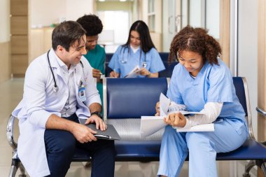 Çeşitlilik doktoru ve hemşire, uzman hekim tecrübesiyle tam bakım planı için gerekli teşhisten sonra hastanın tıbbi kayıtlarını tartışıyor ve beyin fırtınası yapıyor.