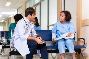 Çeşitlilik doktoru ve hemşire, uzman hekim tecrübesiyle tam bakım planı için gerekli teşhisten sonra hastanın tıbbi kayıtlarını tartışıyor ve beyin fırtınası yapıyor.