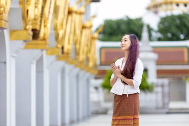 Buddhist asian woman is doing walking meditation around temple for peace and tranquil religion practice clipart
