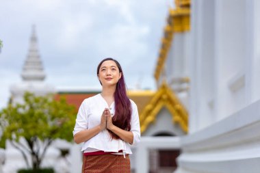 Buddhist asian woman is doing walking meditation around temple for peace and tranquil religion practice clipart