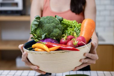 Asyalı ev hanımı, vejetaryen ve vejetaryen yiyecekler için basit ve kolay Japon yemekleri hazırlamak için çeşitli organik sebzeler gösteriyor.