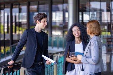 Çeşitli iş adamları, yeni proje ve planlama için ofis binasında dolaşırken yatırım gayrimenkulleri konulu yeni stratejik strateji projeleri hakkında tartışıyorlar.