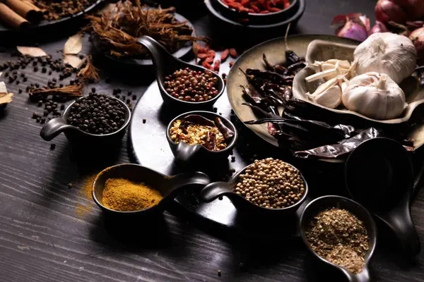 stock image Various type of oriental earthy flavor dry spice on dark wooden table such as black pepper, cinnamon, bay leaf, for medicinal and herbal use in healing and cooking