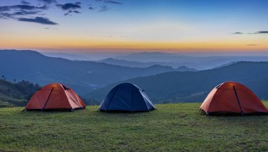 Bir grup maceraperest çadır gece kamp alanında güzel manzaralı gün batımı manzarası dağların tepesinde maceraperest seyahatler için