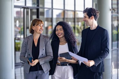 Çeşitli iş adamları yeni proje ve planlama için ofis binasında dolaşırken yatırım gayrimenkulleri üzerine yeni stratejik strateji projeleri üzerinde tartışıyorlar.