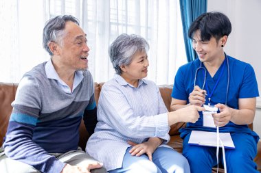 Üst düzey çift, sağlık ve emeklilik sigortası için nabız oksimetresinden yapılan tıbbi muayenenin sonucu olarak evde erkek bakıcı hemşirelerden tıbbi hizmet aldı.