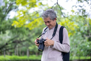 Asya 'nın son sınıf öğrencisi ormanda yürürken aynı zamanda yaşlılara özel bir egzersiz ve doğa terapisi için fotoğraf çekiyor.