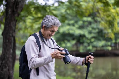 Asya 'nın son sınıf öğrencisi ormanda yürürken aynı zamanda yaşlılara özel bir egzersiz ve doğa terapisi için fotoğraf çekiyor.