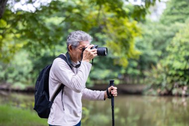 Asya 'nın son sınıf öğrencisi ormanda yürürken aynı zamanda yaşlılara özel bir egzersiz ve doğa terapisi için fotoğraf çekiyor.