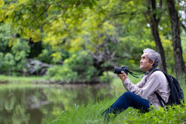 Asya 'nın son sınıf öğrencisi ormanda yürürken aynı zamanda yaşlılara özel bir egzersiz ve doğa terapisi için fotoğraf çekiyor.
