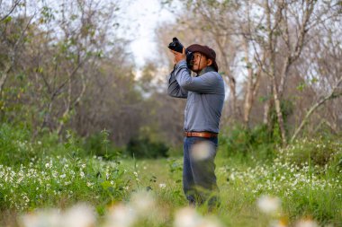 Fotoğrafçı, ender biyolojik çeşitlilik ve alan araştırmaları için orman ormanlarını yabani çiçek çayırlarıyla keşfederken fotoğraf çekiyor.