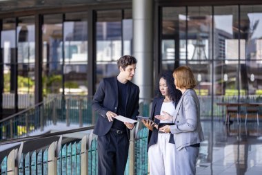 Çeşitli iş adamları yeni proje ve planlama için ofis binasında dolaşırken yatırım gayrimenkulleri üzerine yeni stratejik strateji projeleri üzerinde tartışıyorlar.