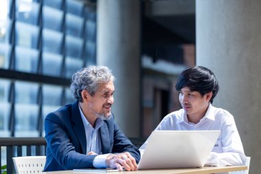 Üniversitede eğitim, akademik ve iş konsepti fakültesinde otururken, Asyalı son sınıf profesörü üniversite öğrencilerine araştırma tezi hakkında tavsiyelerde bulunuyor.