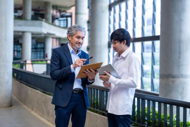 Üniversitede eğitim, akademik ve iş konsepti fakültesinde otururken, Asyalı son sınıf profesörü üniversite öğrencilerine araştırma tezi hakkında tavsiyelerde bulunuyor.