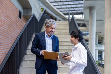 Asyalı son sınıf profesörü, üniversite fakültesi eğitim, akademik ve işletme fakültesinde otururken üniversite öğrencisine araştırma tezi hakkında tavsiyelerde bulunmaktadır.